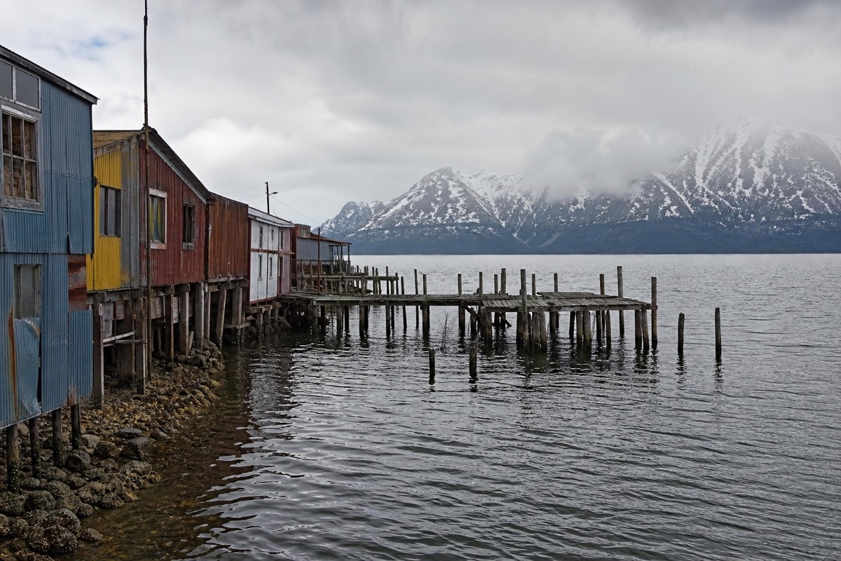 Fishing boats and painted houses along the Puerto Natales waterfront on the fjord