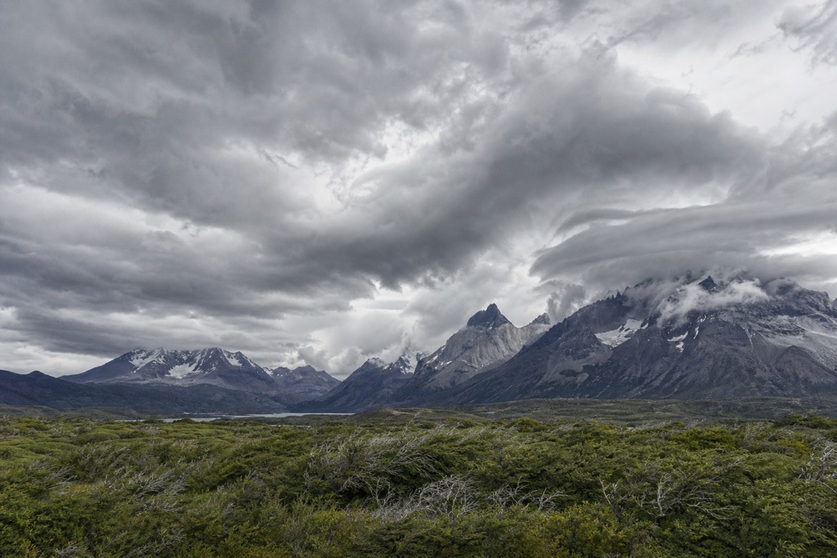 Storm clouds building over jagged Patagonian granite peaks above open ground